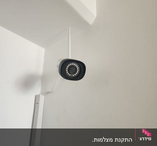 מצלמת אבטחה מותקנת על קיר לבן